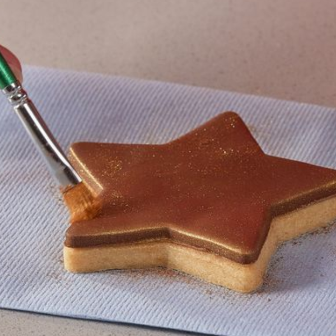 Lustre dust spread onto chocolate biscuit coating