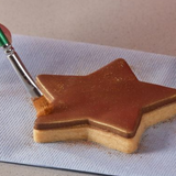 Lustre dust spread onto chocolate biscuit coating