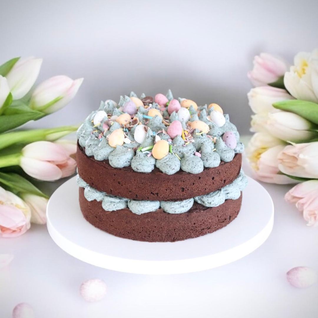 Chocolate Easter layer cake topped with pastel mini eggs and buttercream