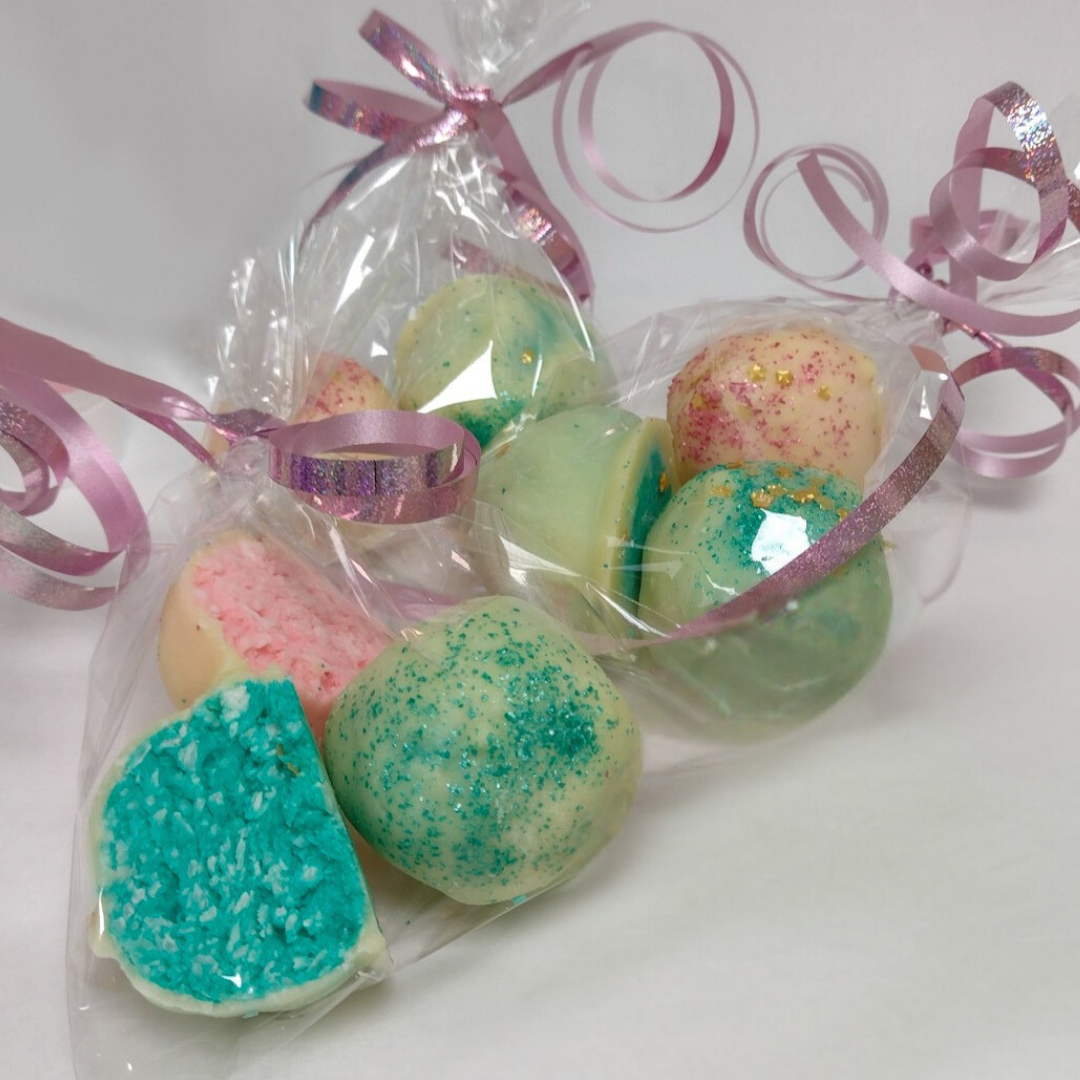 Pastel glitter-coated festive bites in a cellophane gift bag with pink ribbon
