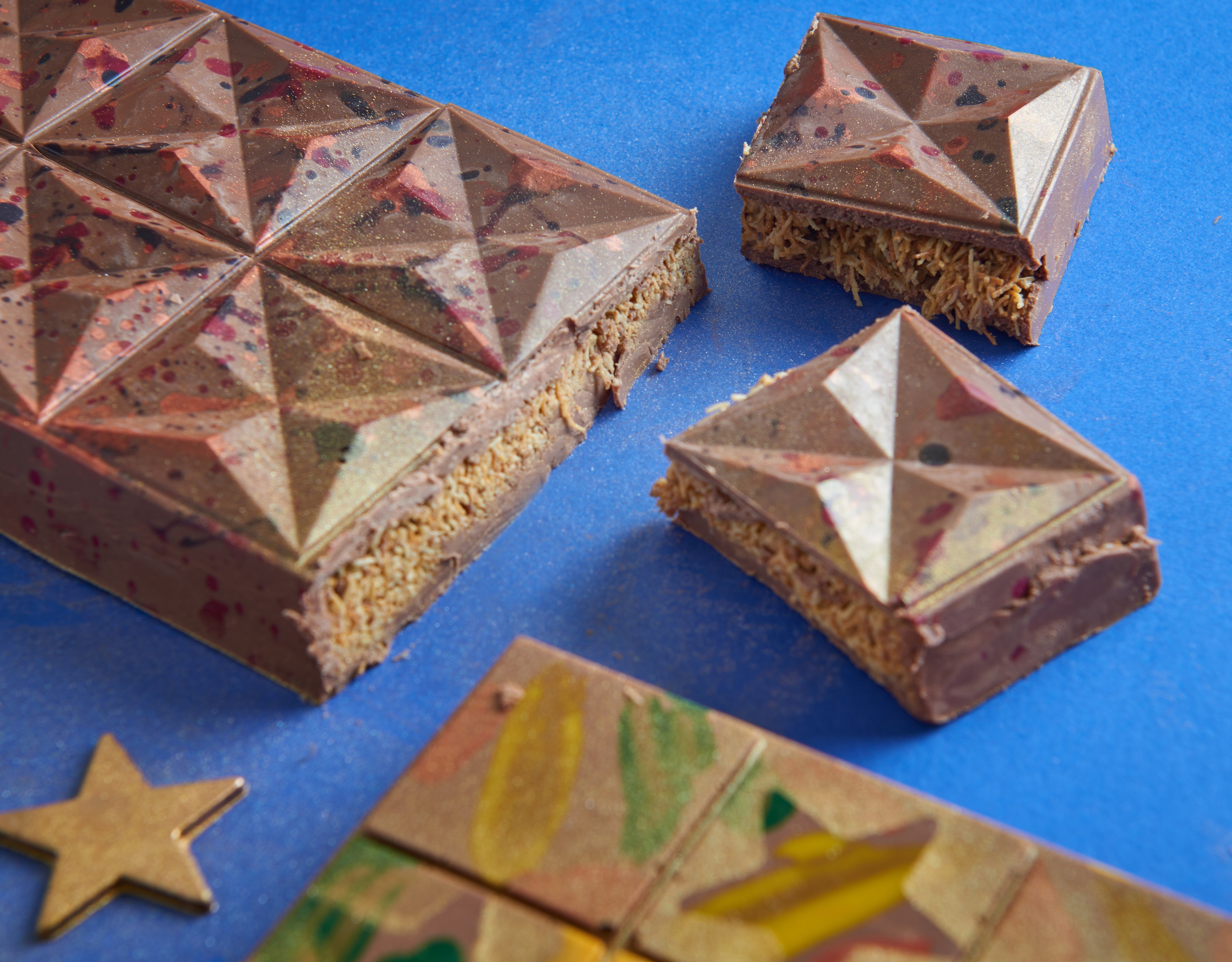 Chocolate pistachio bars decorated with geometric metallic chocolate panels