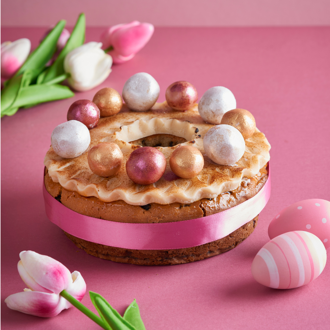 Simnel ring cake with toasted marzipan eggs on a pink Easter table