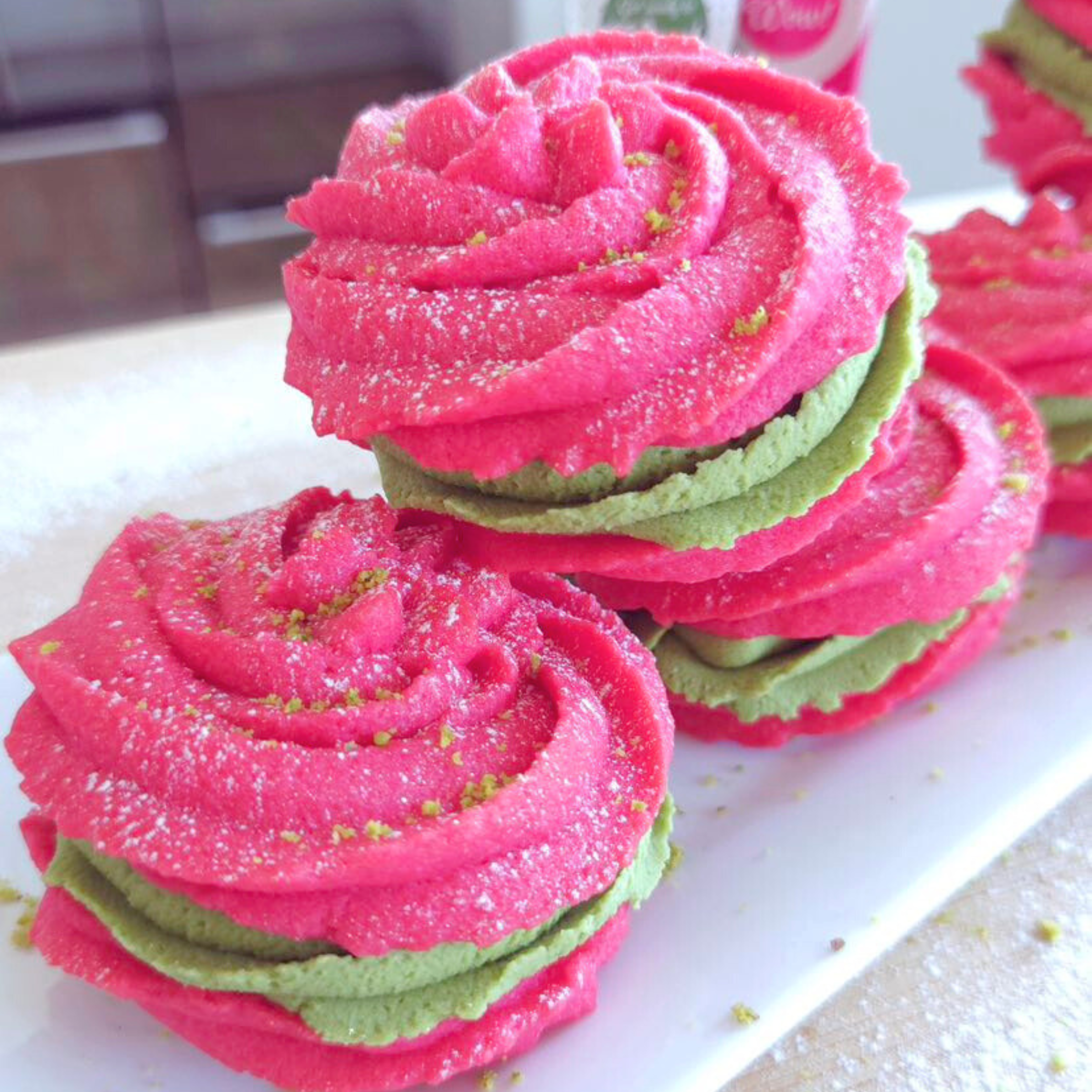 Bright pink Viennese whirls filled with green pistachio buttercream