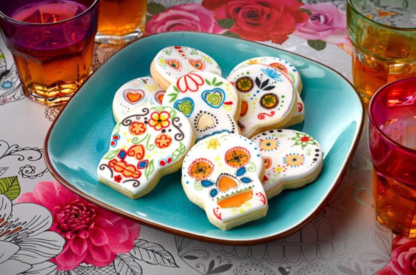 Colourful floral sugar skull cookies on a turquoise plate
