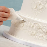 Piping royal icing onto a wedding cake